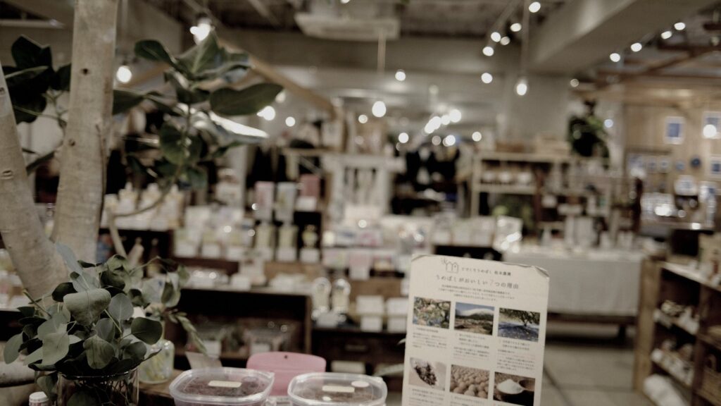 ヒューマンフォーラム様の店内。木の什器に商品が並び、手前に印刷されたPOPが立つ